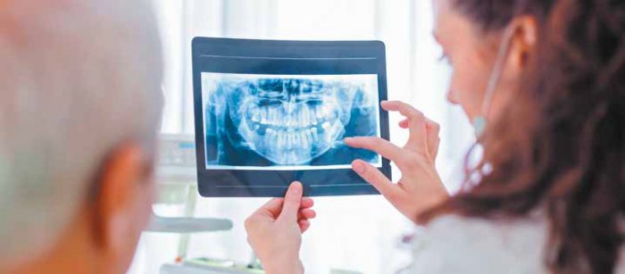 Dentist holding patient x-ray